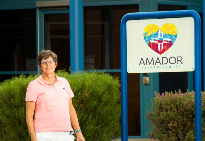 An Amador Health Center professional standing next to the Amador Health Center sign