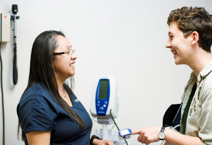 A patient talking and laughing with a medical professional